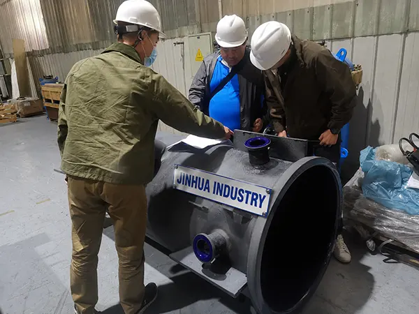 JINHUA senior engineers in safety helmets verifying CAD blueprints against a custom fabricated glass lined vessel