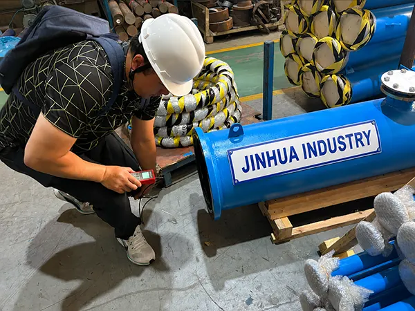 Inspector using glass thickness digital measuring tool on a glass-lined piping section before export packaging